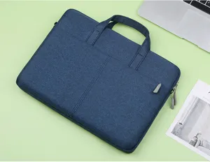 Blue oxford cloth laptop bag detail view, showing handle and front pocket for office.