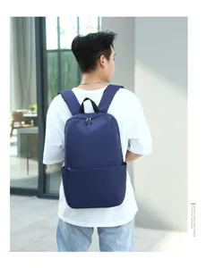 Minimalist solid blue backpack back view display scene, lightweight casual daily bag details.