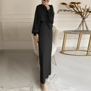 Detail view of a solid black long sleeve maxi dress with stylish puffy sleeves and waist belt.