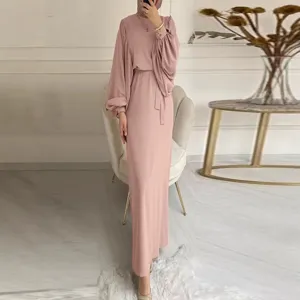 Elegant pink long sleeve maxi dress detail in indoor setting, featuring chic waist tie.