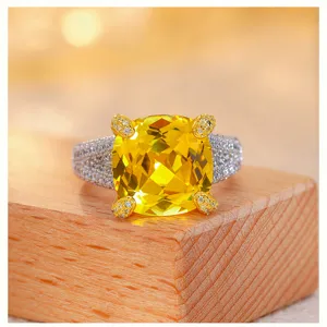 Detailed view of the luxury cushion-cut yellow gemstone ring with sparkling pave side stones.