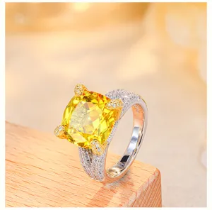 Exquisite cushion-cut yellow gemstone ring with pave band close-up showcasing bright fire.