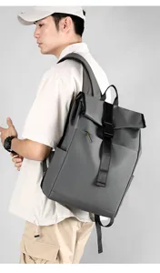 Detail view of a stylish gray roll-top backpack worn by a model, showcasing its large capacity.
