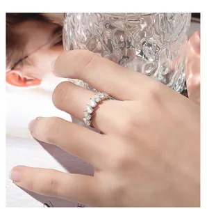 Close-up lifestyle detail shot of a sparkling pear-cut moissanite 7-stone band ring worn.