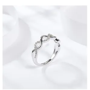 Detailansicht des silberfarbenen wellenförmigen verdrehten Pavé-Rings mit edlen Steinen.