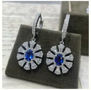 Detailed view of silver-plated drop earrings featuring a blue oval stone with white zirconia.