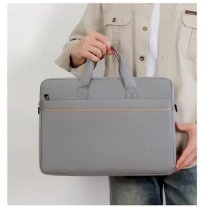 Dettaglio borsa per laptop grigia che mostra manico resistente, cerniera liscia e comoda tasca.