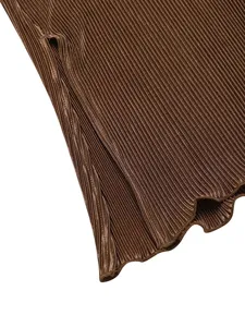 Close-up detail of the elegant pleated long dress showing fabric texture and side slit.