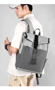 Close-up detail view of the grey roll-top backpack worn by a model, showing adjustable straps.