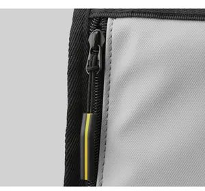 Backpack detail shot showing durable grey fabric, black zipper and yellow stripe pull.