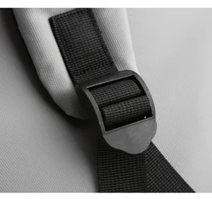 Close-up detail of backpack strap and black plastic adjustable buckle, durable design.