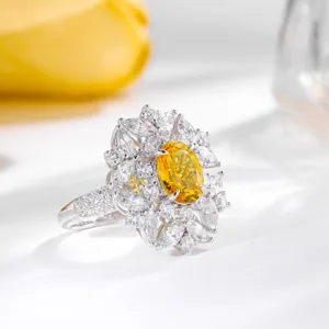 Stunning oval yellow synthetic gemstone ring with sparkling white cubic zirconia cluster.