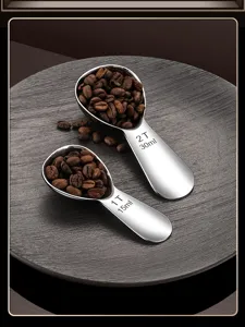 Close-up view of stainless steel measuring coffee spoons featuring clear engraved capacity scales.