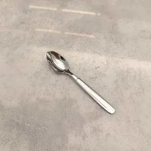 Vue détaillée de cuillère en acier inoxydable, surface polie et manche lisse pour le repas.