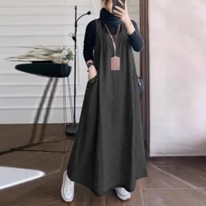 Detailed view of casual loose denim overall dress with big pockets for autumn wear.