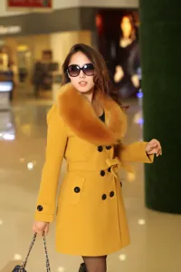Manteau femme laine jaune croisé d'hiver trench avec col en fausse fourrure et une ceinture.