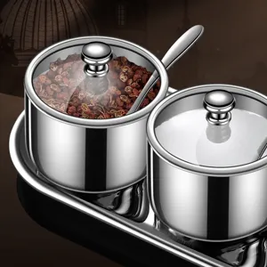 Stainless steel condiment jar set with glass lids and spoons, kitchen storage spice container.