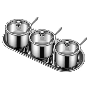 Stainless steel seasoning jar set with lids and tray for kitchen spice storage.