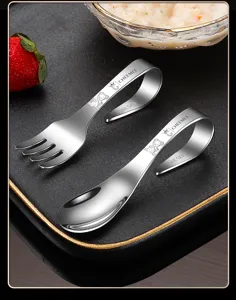 Détail de set cuillère et fourchette bébé en inox avec poignée ergonomique et motif d'ours.