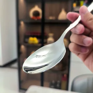 Détail de cuillère en acier inoxydable avec finition miroir polie pour une belle table.