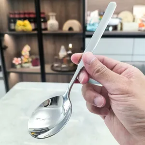 Détail de cuillère en acier inoxydable avec long manche et bol rond poli pour repas.