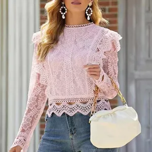 Detail view of pink lace long sleeve crop top with delicate hollow-out floral lace design.