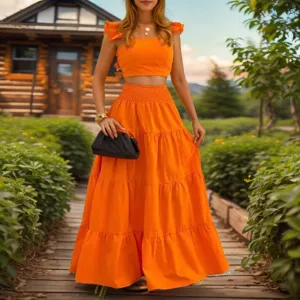 Elegantes orangefarbenes Zweiteiler-Set mit Rüschen-Crop-Top und gestuftem Maxirock.