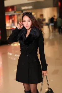 Vue detaillee du manteau de laine noir pour femme avec grand col en fourrure et double boutonnage.
