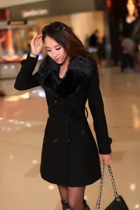 Manteau en laine noir pour femme avec col en fausse fourrure hiver élégant.
