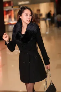 Manteau femme en mélange de laine noire avec col fausse fourrure et ceinture élégante.