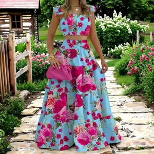 Detail des blumigen Zweiteilers mit blauem Crop-Top und Stufen-Maxirock im Garten.