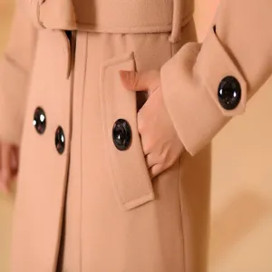 Vue détaillée du manteau en laine beige pour femme avec des boutons croisés et des poches.