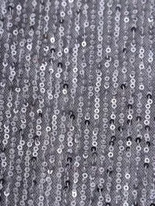 Gros plan de tissu à sequins argentés scintillants pour vestes de blazers élégantes.