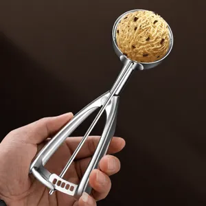 Stainless steel ice cream scoop with trigger release melon baller for fruit dessert.