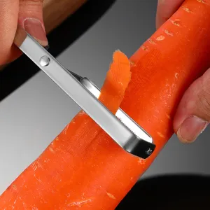 Detalle de pelador de verduras de acero inoxidable con cuchilla precisa para zanahorias.