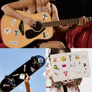 Detailansicht von Cartoon Werkzeug Aufklebern auf Gitarre und Laptop zur Dekoration.