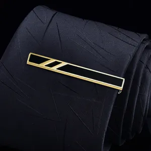 Detail shot of a golden metal tie clip with black enamel finish, elegant business accessory for men.