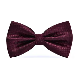 Close-up detail of burgundy red bow tie with subtle grid pattern, premium fabric texture.