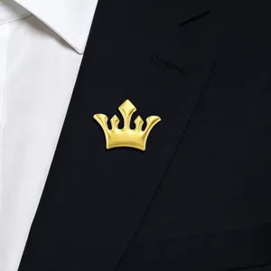 Close-up view of a luxurious gold crown brooch pinned on a dark suit lapel, premium detail.