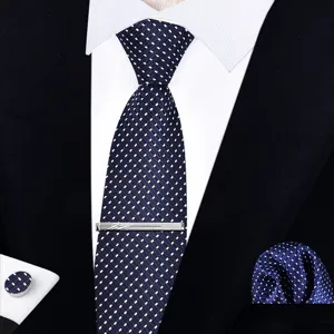 Vista detallada del elegante conjunto de corbata azul marino con patrón y clip metálico.