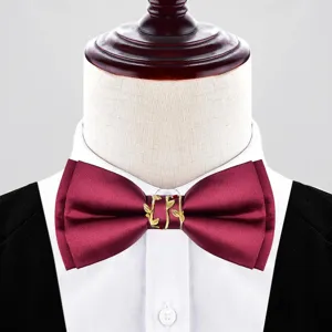 Primo piano del papillon bordeaux da sposo con fibbia a foglia d'oro, accessorio elegante.