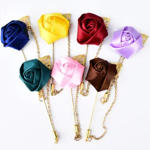Elegant fabric rose flower brooch with long gold chain and leaf detail, multi-color accessory.