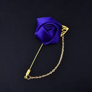Exquisite blue fabric rose boutonniere brooch with gold chain and leaf detail for wedding groom.