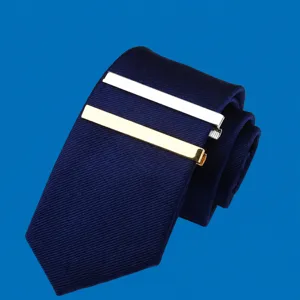 Detailed view of a classic men's dark blue woven tie paired with sleek gold and silver metal tie clips.