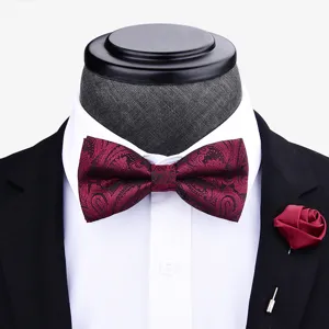 Detail view of burgundy paisley bow tie and matching lapel flower for men wedding suits.