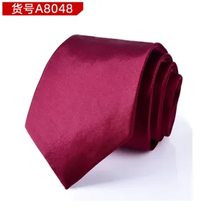 Close-up detail of a classic burgundy silk-textured men's formal tie, elegant rolled design.