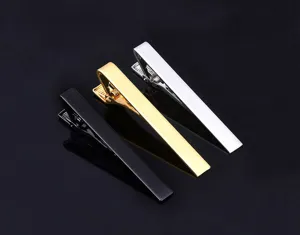 Detailed view of classic metal tie clips in black, gold, and silver color finishes.