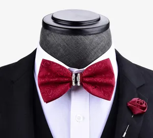Dettaglio del farfallino bordeaux fantasia con centro in strass e spilla con rosa abbinata.