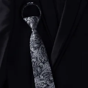Close-up detail of a black and grey paisley pattern zipper tie, British gentleman style.