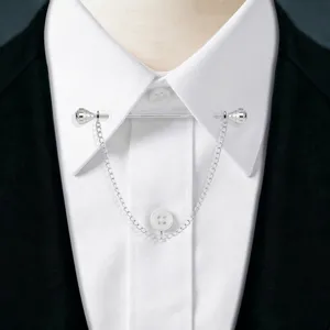 Close-up detail of silver-tone collar pin with chain and crystal ends, elegant shirt accessory.